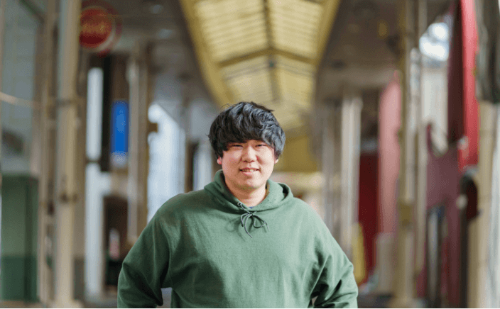 商店街に男の人が立ってこちらを見ている